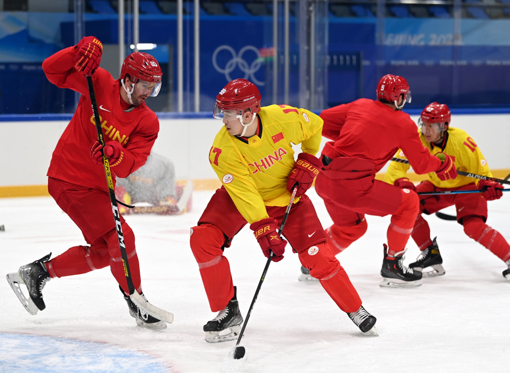 1月29日,中国男子冰球队队员骆嘉(前右)与建安在训练中拼抢.
