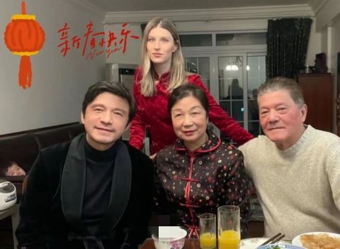 谢晖把儿子抱在怀里,妻子依偎在身旁,一家三口同框的画面看上去温馨有