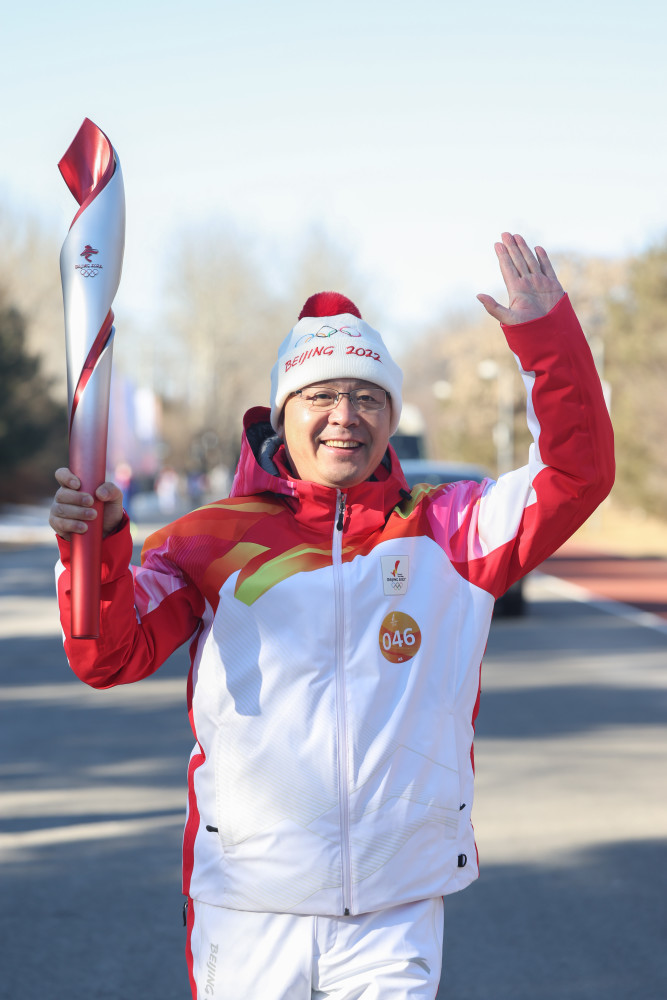 2月2日,火炬手张旭阳(左)与崔景山进行火炬传递