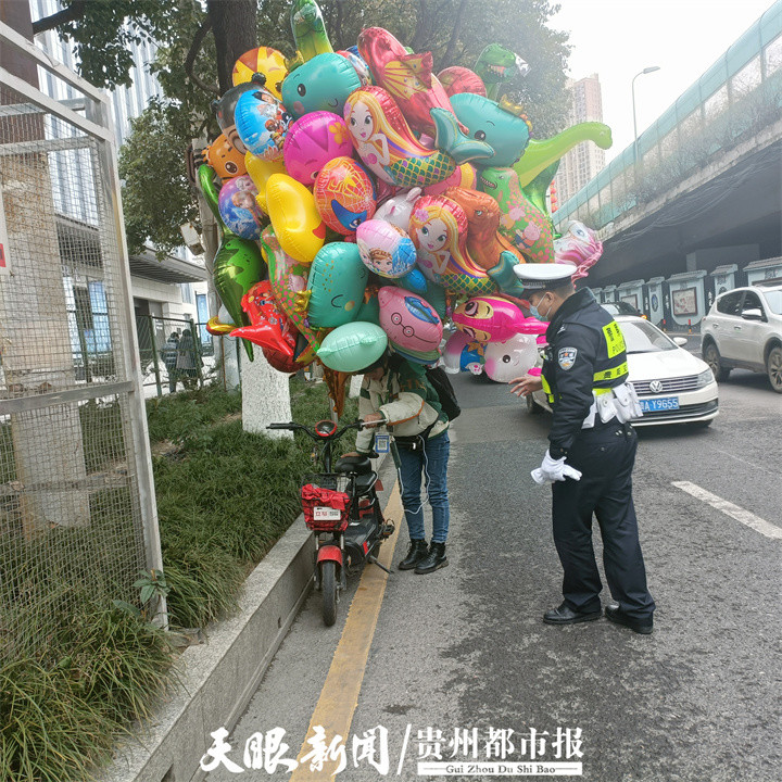 女骑手背氢气球出行贵阳交警及时消除移动炸弹