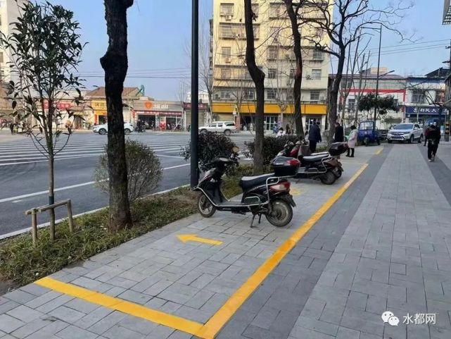 2月10日,在丹江口市姚沟路,市城管执法人员同车位施划人员在完成地面