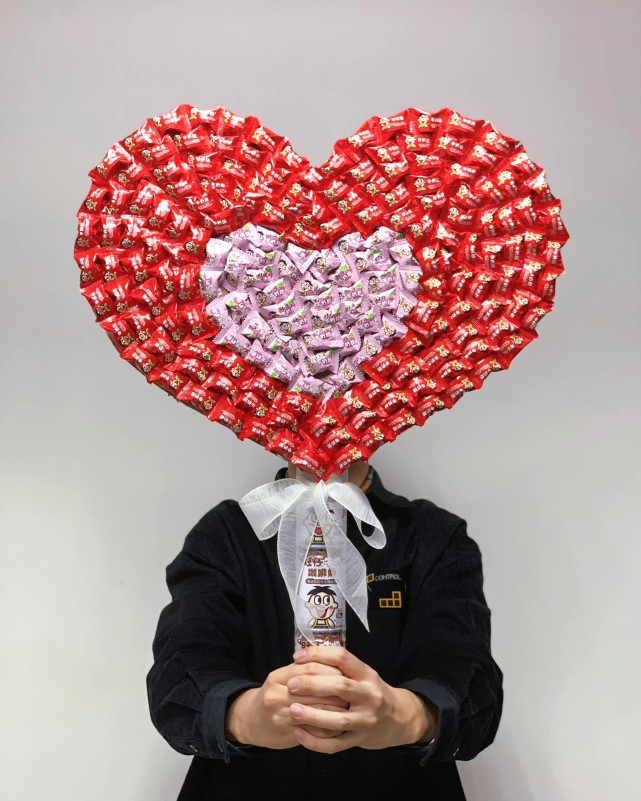 它选择用普通的牛奶糖与旺仔牛奶拼成巨大的爱心花束,给消费者制造