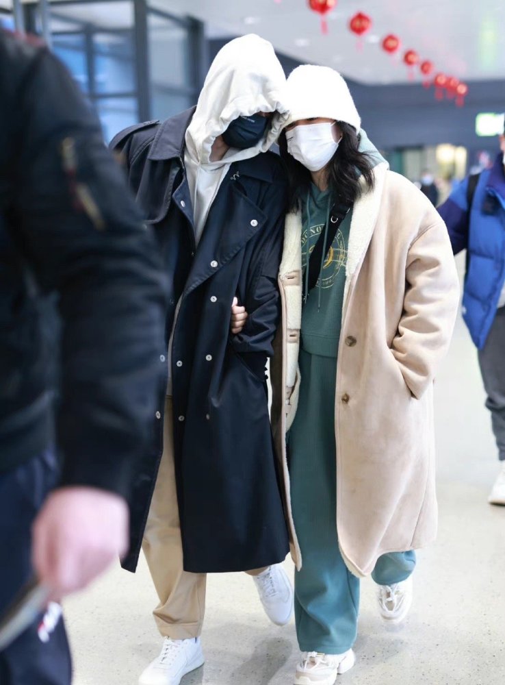 甜蜜张杰谢娜情人节现身机场打扮低调休闲一路挽手前行