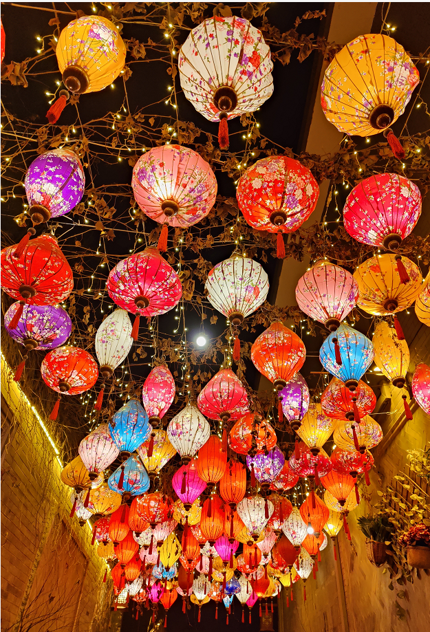 河面上,树木上均布置了各种形态各异的灯组,临夏市八坊十三巷的亭台楼