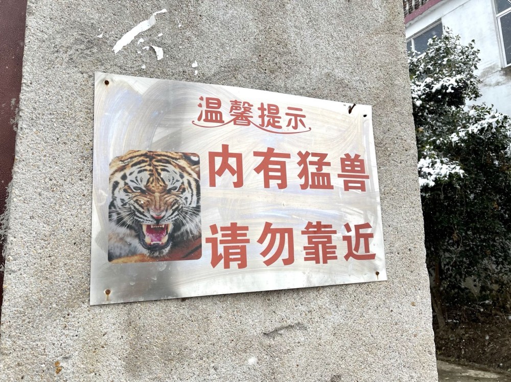 没多远,便到了一处张贴"内有猛兽,请勿靠近"标识牌的人家.