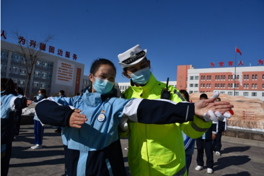 2 月 21 日,新源县公安局交警大队民警给"弘毅交警班"的小交警们纠正