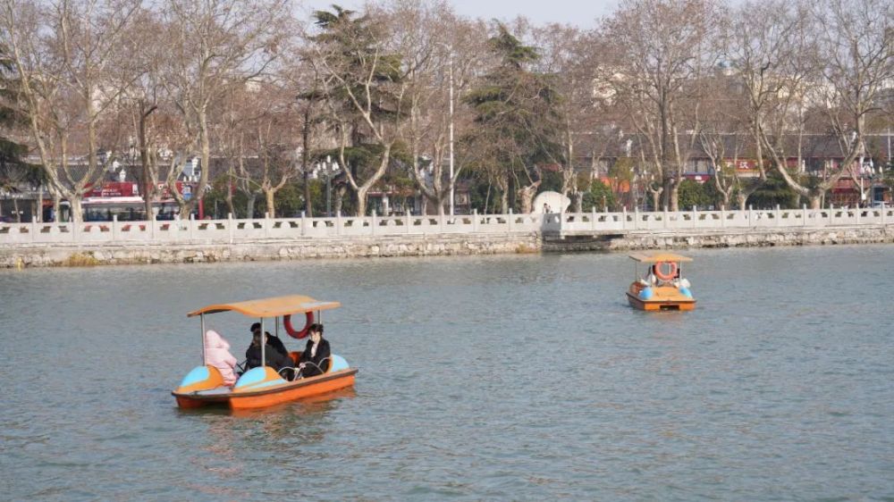 很多家长带着小朋友一起来划船在襄阳公园一边享受惬意的春日暖阳游客