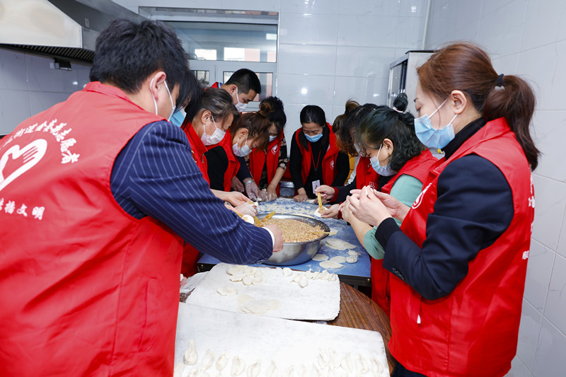 长春汽开区东风街道创业社区开展学雷锋日包饺子献爱心活动