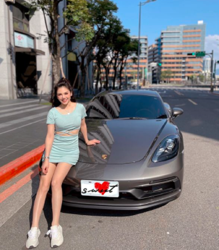 100万人民币)的某时捷跑车,她穿着露腰的短裙倚坐在车头,秀出一双美腿