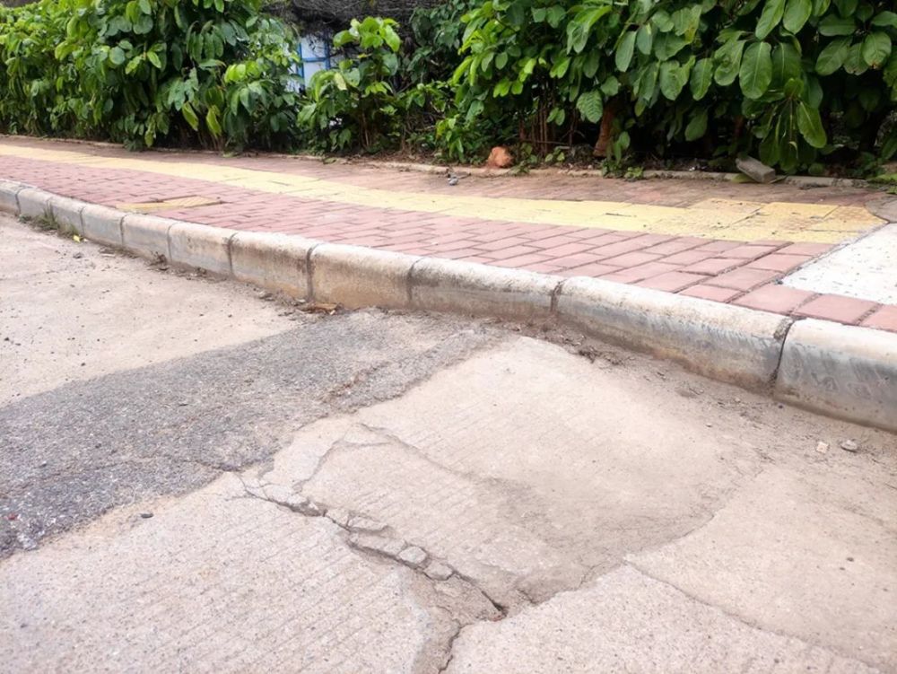 发现数百米的水泥路面裂痕遍布,其中不少坑洼处有被沥青混凝土简单