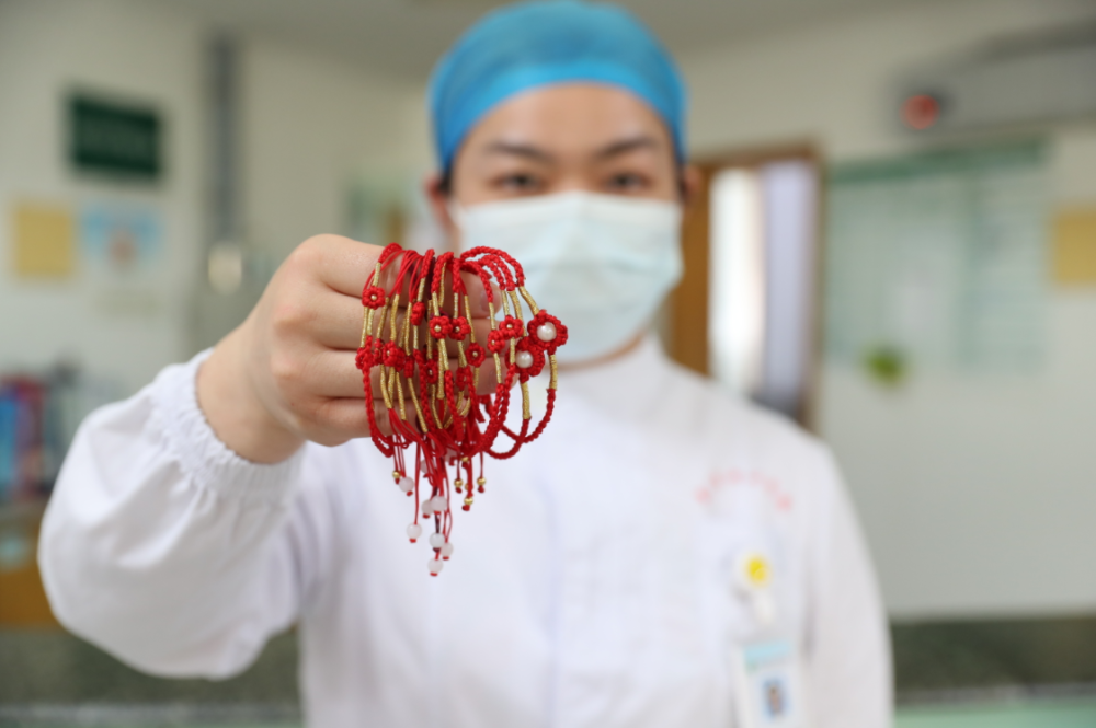 护士手工编织红手链鼓励关爱乳腺癌患者