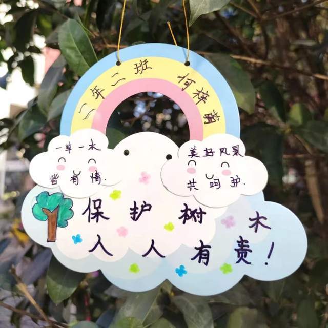 一手提小桶,一手握小刷子,来到小树前,用心爱护它.