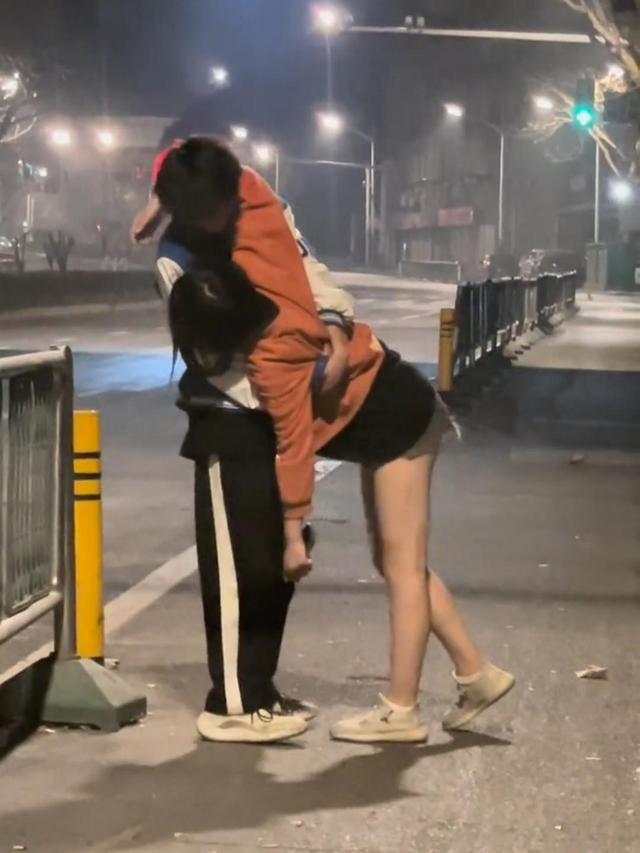 男生的肩上挂着女生的包包,显然,他们刚才一起去喝酒了,只是不知道
