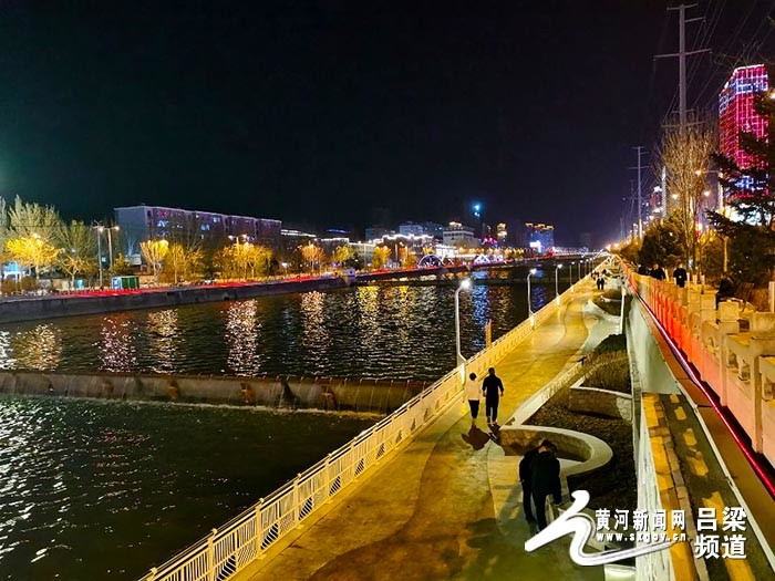 华灯初上,吕梁市区东川河绚丽的灯光与河水交织出一幅美丽的夜景,把