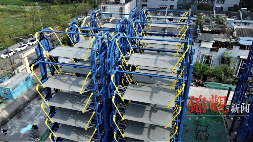 在静安路垂直循环立体车库施工现场,工人们在搬运建材,焊接钢筋,各种