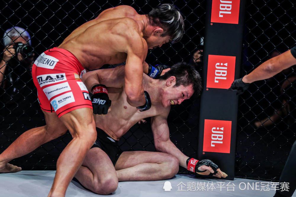 开局后,青木真也直接扑上来,爬到秋山成勋背上,搭成身体三角,想布置