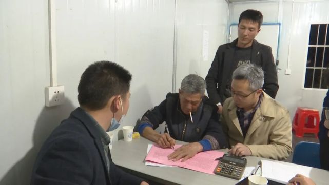 鎮馮圍村七組村民張錫學老漢在房屋徵遷協議書上鄭重簽名