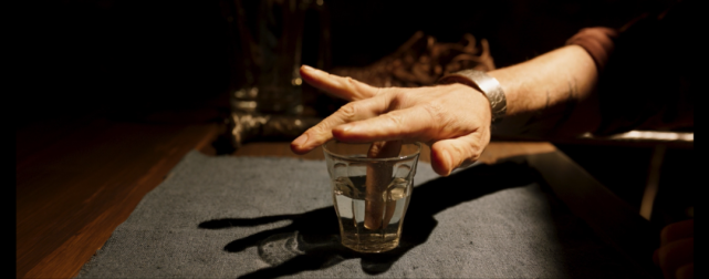 他先是用中指沾水绕杯壁一圈,再把水喝掉.