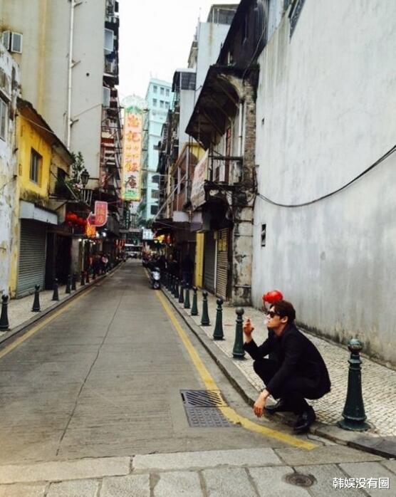 在公开的照片中,吴尚津蹲在香港的某条街头,手上夹着香烟,正在吞云吐