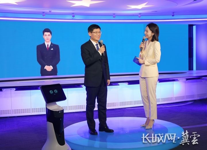 程俊峰与虚拟主持人,机器人进行互动,解读"精细服务".
