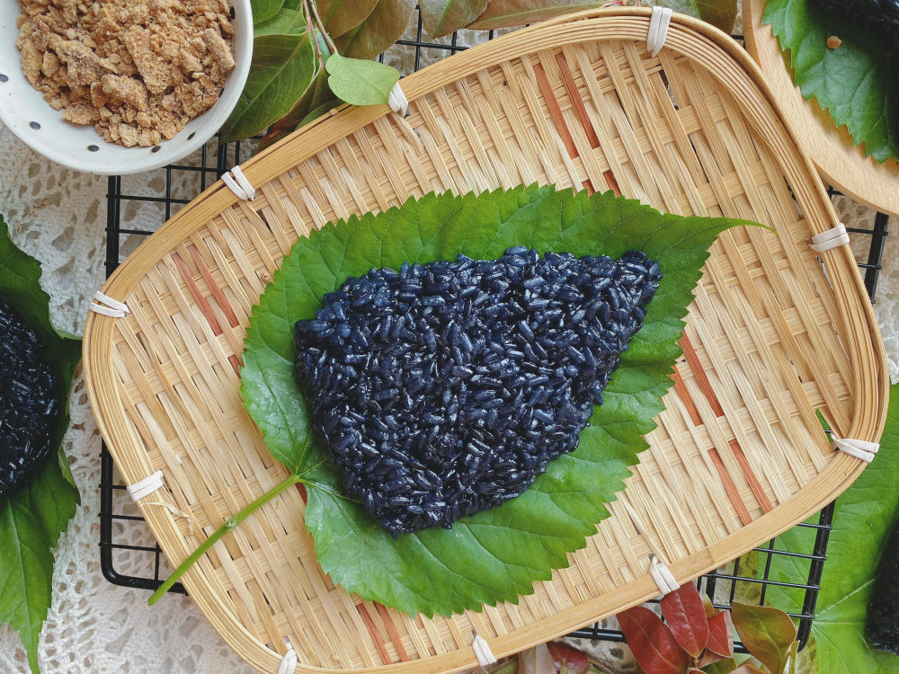 乌稔饭是畲族在清明节必吃的一种美食,白色的糯米用一种特殊的"树叶"
