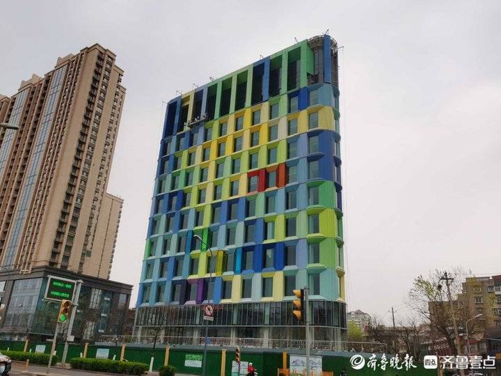 在花园路与花园庄东路的交叉路口,一栋清新马卡龙色的三角大楼建筑