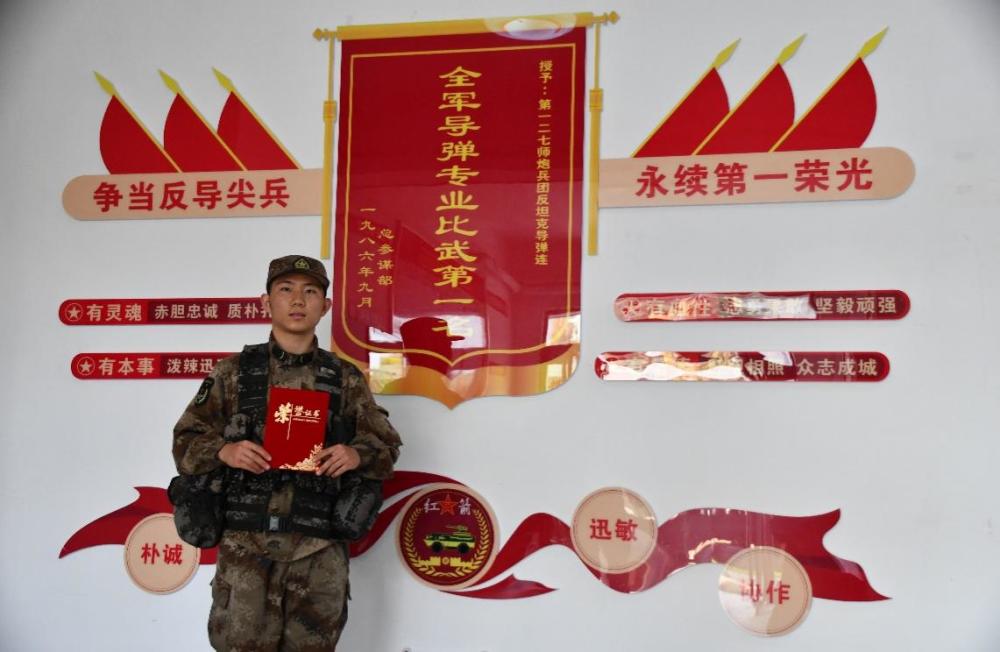 第一次比武获奖后,王德振在连队荣誉墙前合影"争第一,不单是速度