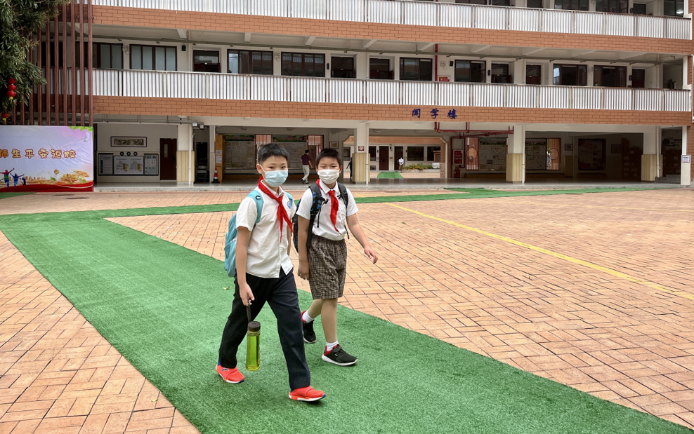 经过测温,检查核酸码后,黄湘岳一行进入西丽小学校园.