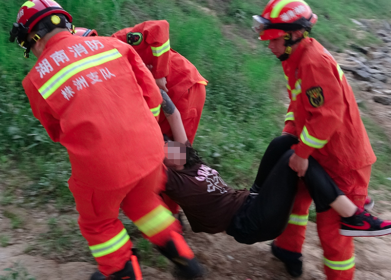为防止被救者着凉,消防救援人员将救生衣垫在地上并脱下上衣盖在被救