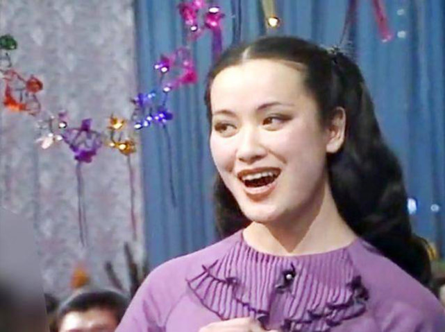 索宝莉穿着一条紫色裙子搭档"东方金嗓子"牟玄甫演唱了这首《夫妻