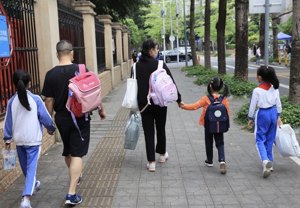 上学路上,家长拿出手机给小朋友拍照留念.▲小朋友学着大人