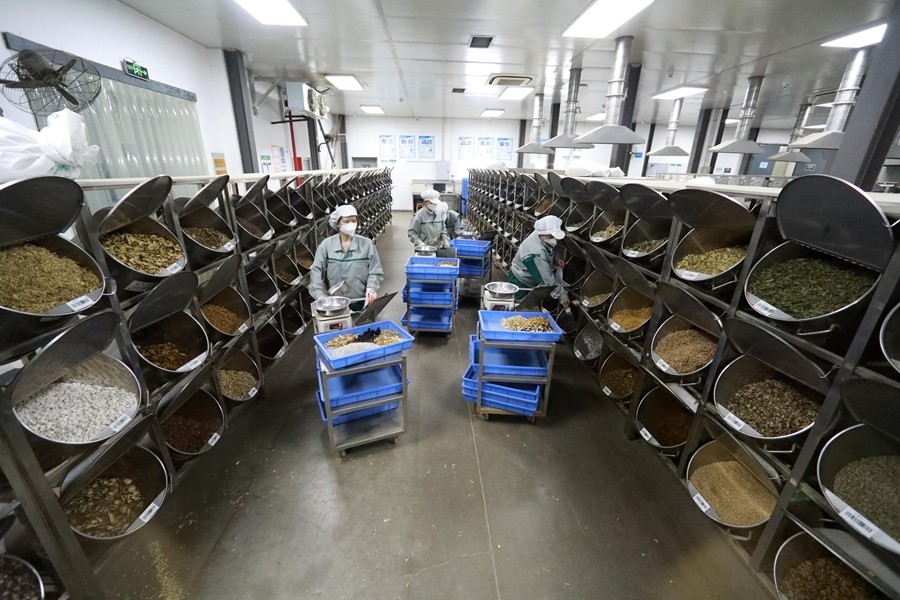 4月18日,在上海上药华宇药业公司生产车间,中药师在调配药材.