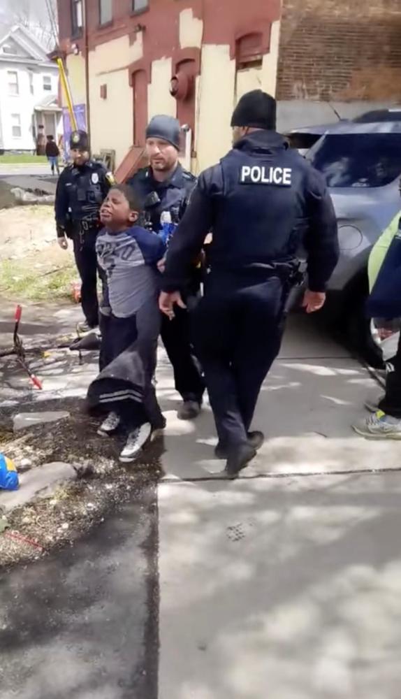 美国8岁黑人小孩在商店偷零食，警察直接把他塞进警车任其哭喊