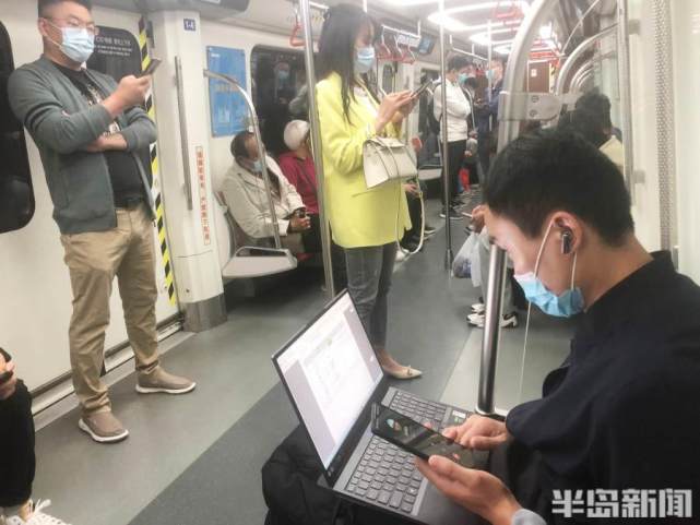 不少上班出行的市民在车厢内低头刷着手机,看电脑忙着工作,听音乐