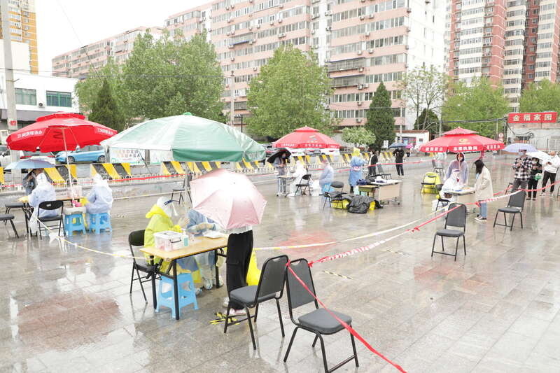 北京朝阳区第二轮核酸检测：居民雨中有序排队等待