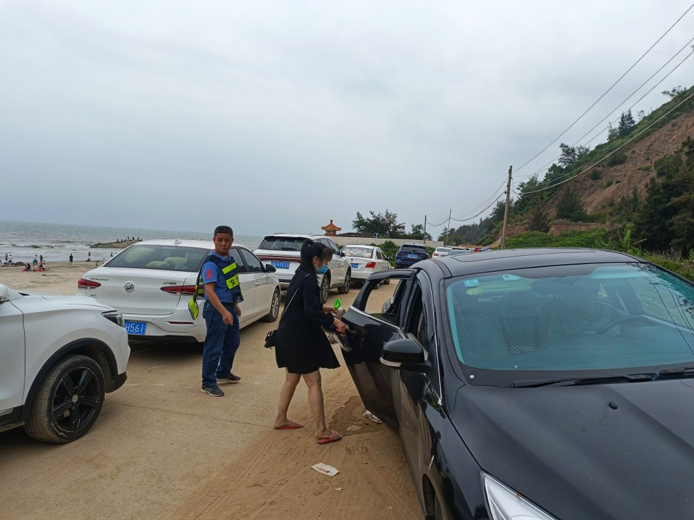 汕尾市城区马宫街道金町村白沙浮海滩的路上,身穿蓝马褂的金町村干部