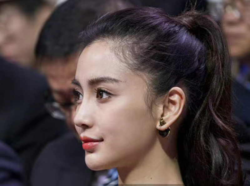 没有露出太多的脖子,大波浪的发型显得颅顶头发稀松扁平,侧面看除了