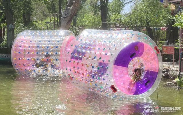 5月1日,孩子们在乌鲁木齐市人民公园玩水上碰碰球,欢度假日.