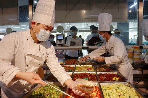 烹饪系学生正在帮厨切菜据了解,扬州大学旅游烹饪学院在五四青年节前