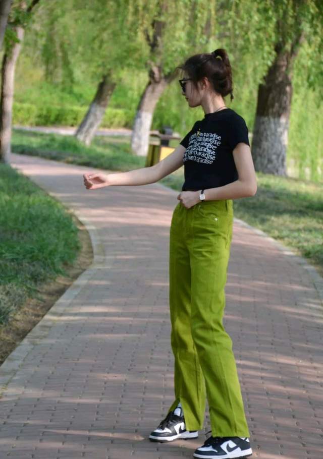 她选择了短款设计的t恤来穿之后还搭配了高腰设计的浅绿色裤子,不仅