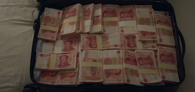 因为刀疤在文队的行李箱里装满了现金,那时王景春饰演的文队还有一个