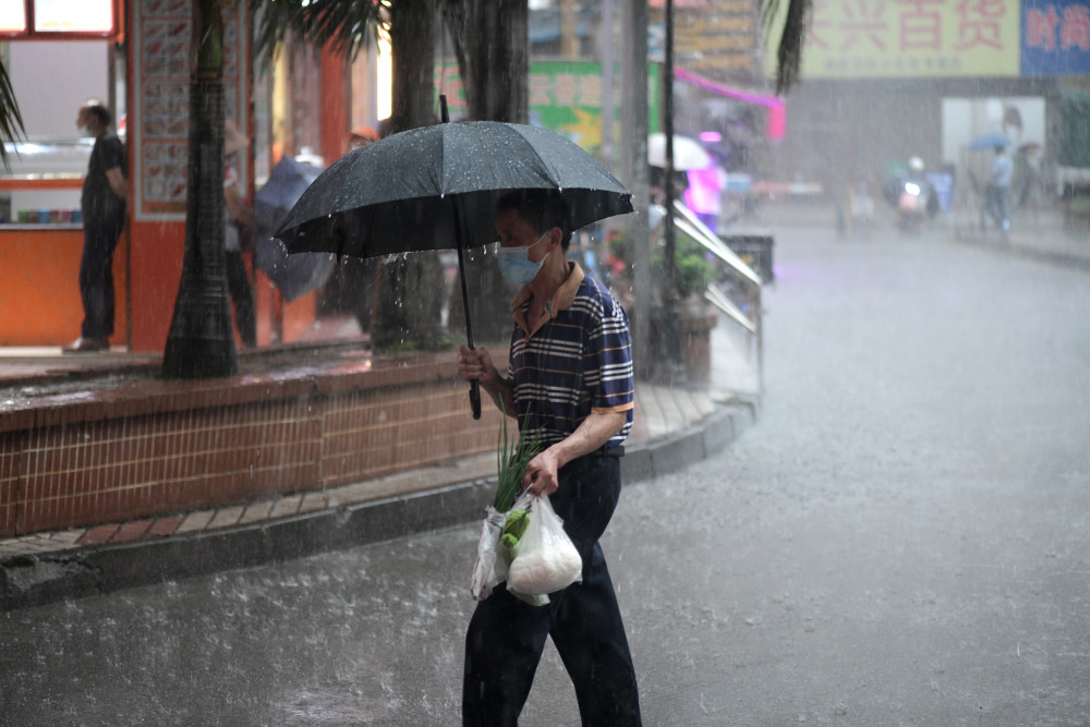 直击广州暴雨市民撑伞冒雨出行