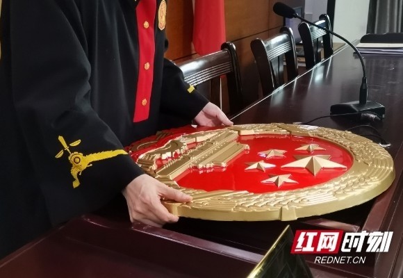 法官将国徽挂在了村民委员会的墙上.