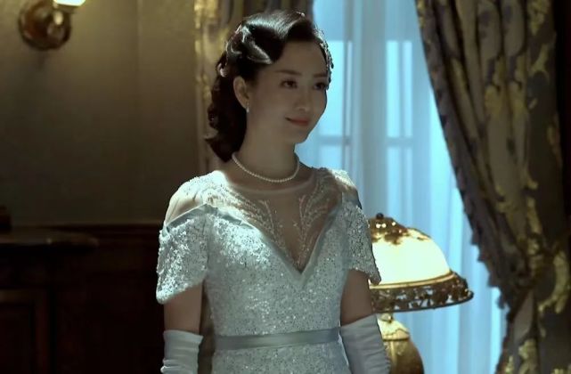 此时的汪曼春身穿一身洁白的礼服,褪去平时那一身铁血的制服,整个人