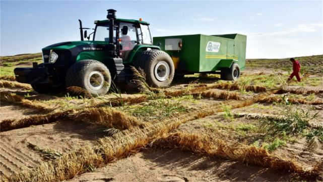 出治沙神器——多功能立体固沙车,可通过横向和纵向输草机构的运转,将