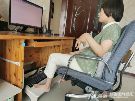 胡婧正用双脚敲击着键盘翻译材料.记者 管梦颖摄