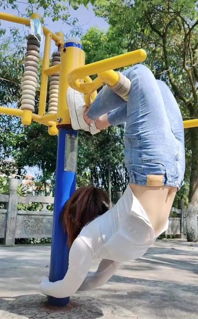 小区公园里,一女子在健身器材上练习下腰,网友羡慕:年轻真好