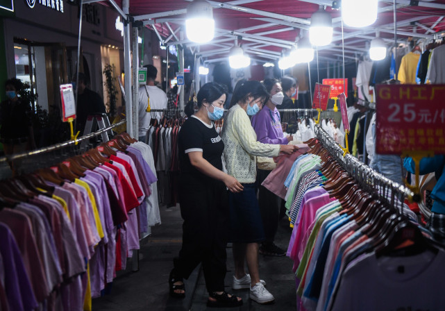 新华社记者 徐昱 摄5月17日,居民在濮院镇佳源夜市的小吃摊挑选美食.