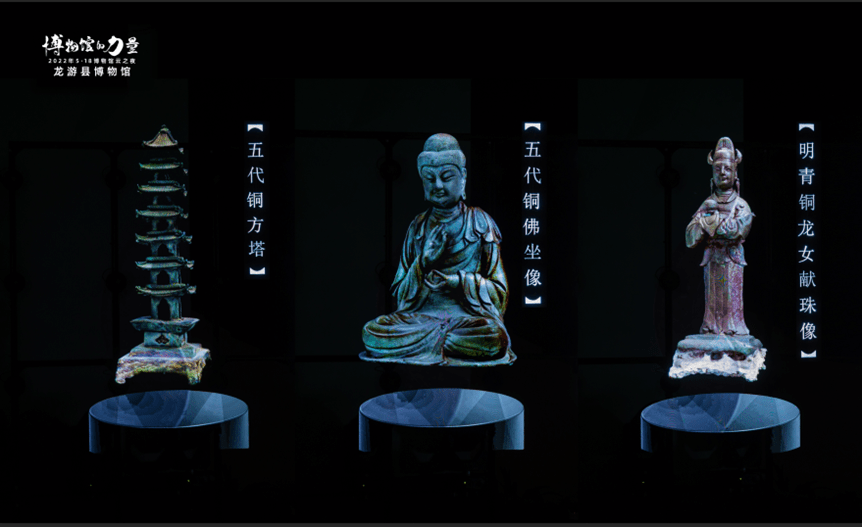 图片展示了三尊佛教雕塑，中间为坐姿佛像，两侧分别是塔和站姿菩萨像，背景为深色，显得庄严神圣。