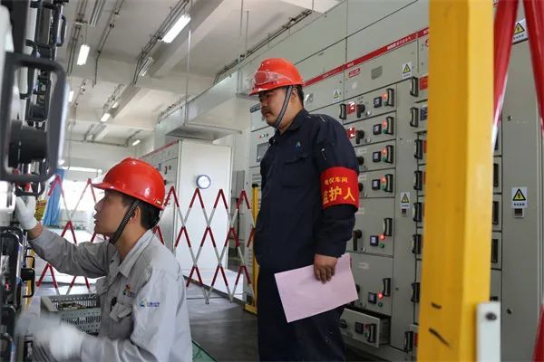 電工鄭輝源正在燒鹼低壓配電室監護低壓抽屜櫃檢查作業(馮銀銀 攝)